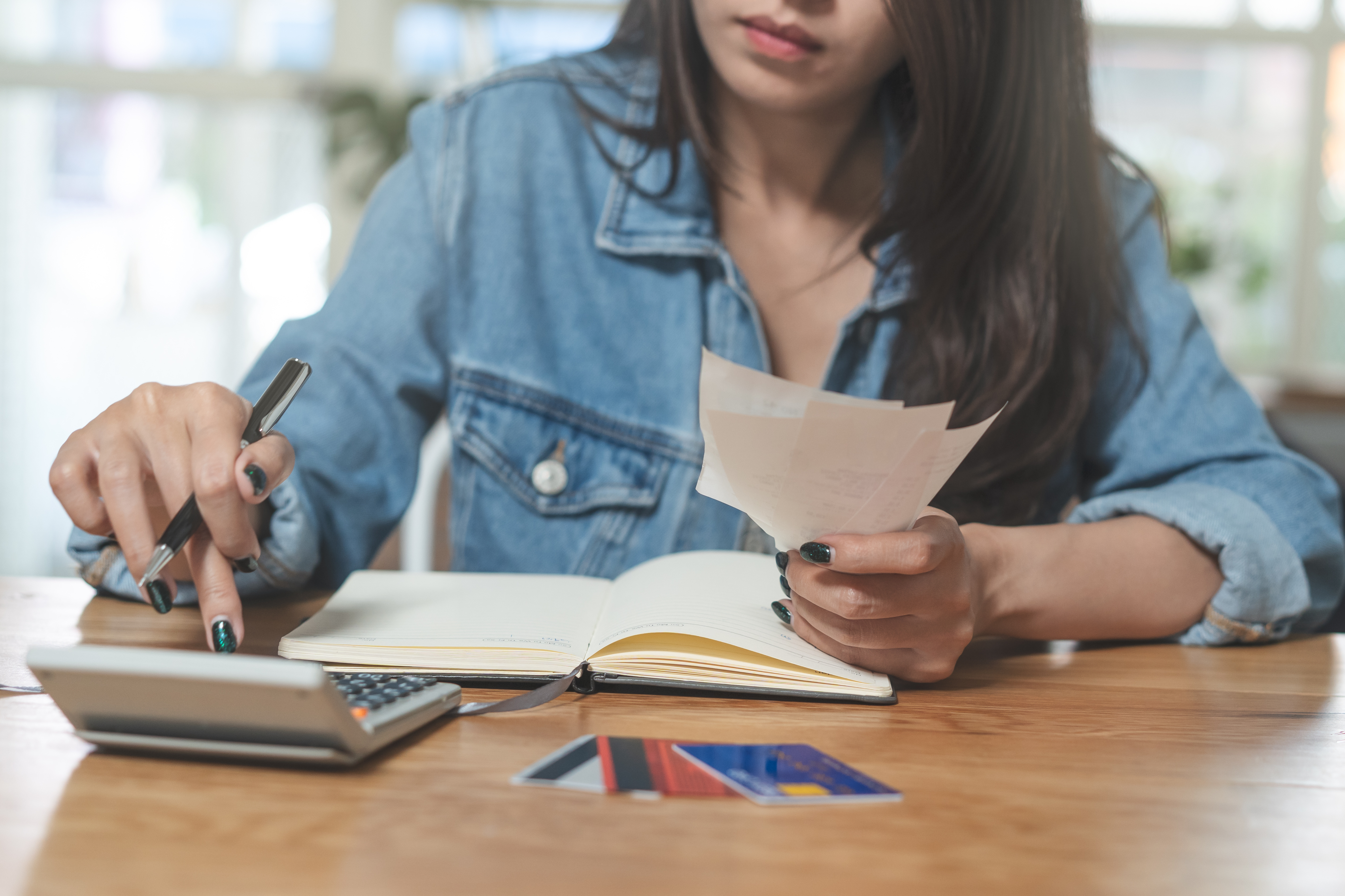 Woman doing accounting home finance expenses and calculate credit card monthly debt to bills payment.